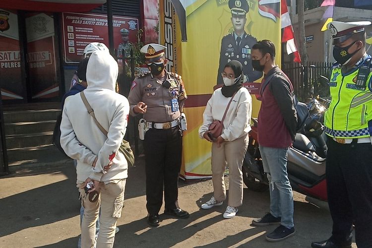 KBO Lantas Polres Bogor Iptu Ketut sedang mengamankan pelaku tukar pelat nomor kendaraan saat ganjil genap di Puncak Bogor, Jawa Barat, Sabtu (4/9/2021).