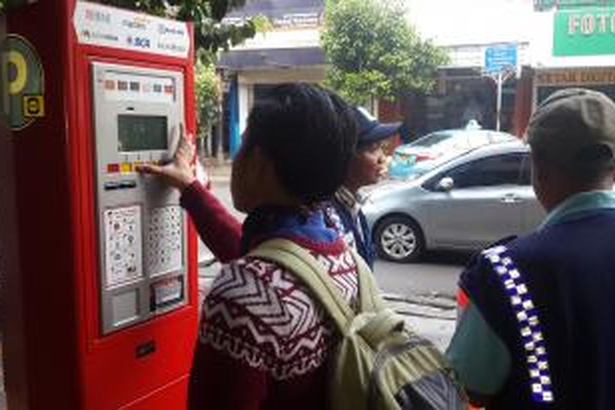 Pengendara saat membayar meteran parkir di Jalan Sabang, Jakarta Pusat, Senin (4/5/2015).