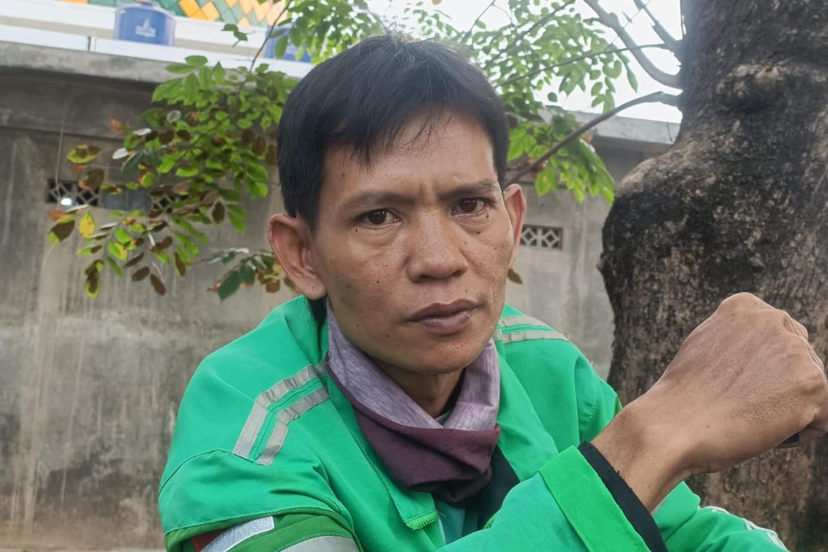 Ahmad Badrawi (43), pengemudi ojek daring saat berbincang dengan Kompas.com di wilayah Sumber Artha, perbatasan antara Bekasi-Jakarta, Rabu (20/9/2023). Ahmad merupakan salah satu pengemudi ojek daring yang memiliki pengalaman melanggar aturan karena terpaksa menuruti kemauan pelanggan.