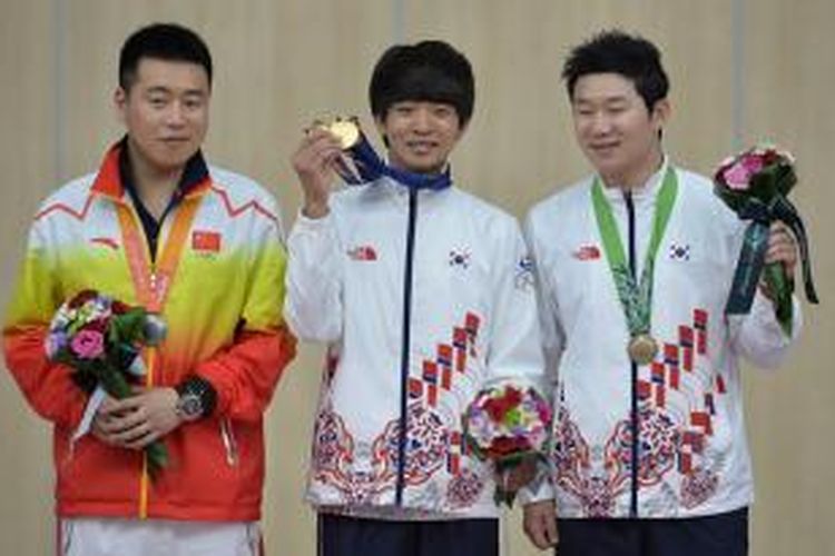 Atlet menembak Korea Selatan, Kim Cheongyong (tengah) berpose bersama atlet Korsel, Jin Jong-oh (kanan), dan atlet Tiongkok, Pang Wei, setelah bertanding di nomor 10 meter air pistol perorangan Asian Games 2014 di Incheon, Korea Selatan, Minggu (21/9/2014).