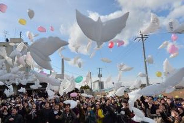 Ratusan balon berbentuk burung merpati dilepaskan sebagai bagian sebuah upacara mengenang korban tsunami di SMP Yuriage, Natori, prefektur Miyagi, Jepang.  


