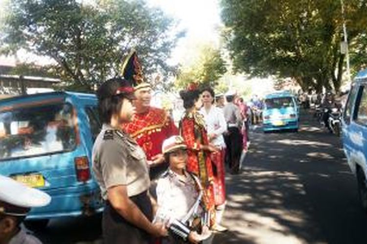 Polisi lalu lintas di Polda Sulut memakai baju adat sambil menghimbau pengendara untuk tertib berlalu lintas dan memperingati Hari Karrini.