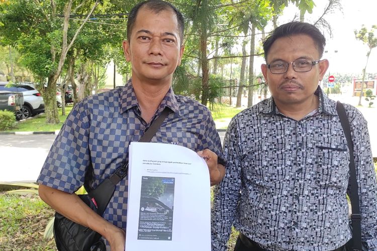 Kader Golkar Sumut Apri Budi (kiri) saat menunjukkan postingan hoaks soal Wali Kota Medan Bobby Nasution di Mapolda Sumut. 