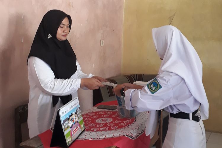 Guru UKS memberikan tablet tambah darah kepada siswi di MTS Ma'arif Sidaraja, Sumedang, Jawa Barat. 