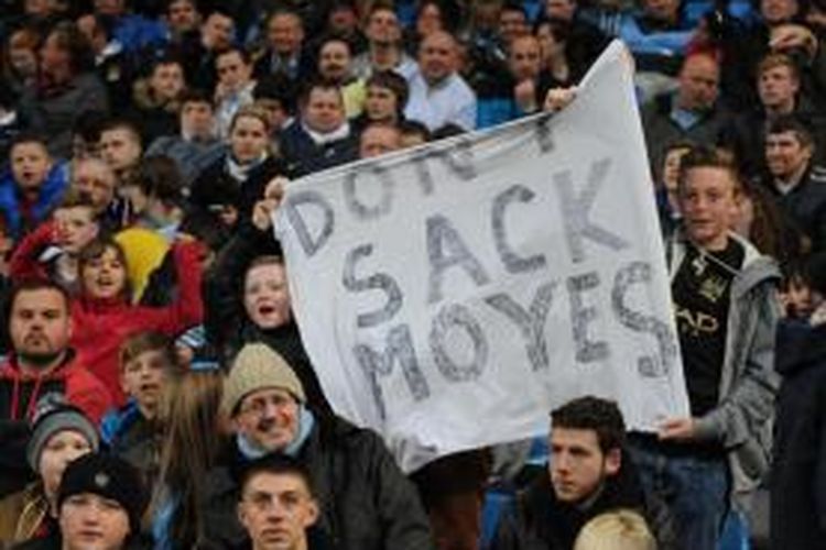 Sejumlah suporter Manchester City membentangkan spanduk yang menyindir Manchester United yang berencana memecat Manajer David Moyes. 