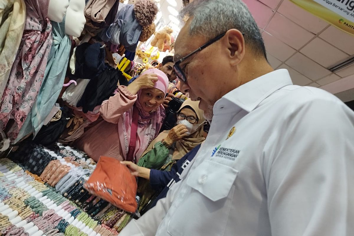 Mendag Zulkifli Hasan melihat kerudung segiempat yang dijual Budi di tokonya saat meninjau Pasar Tanah Abang Blok A, Jakarta Pusat, Jakarta (13/10/2023). (KOMPAS.com/XENA OLIVIA)