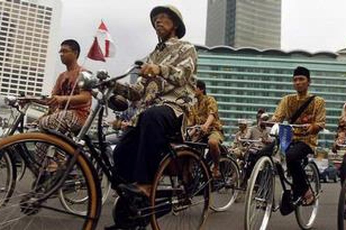 Gabungan komunitas pecinta sepeda tua dengan menggunakan pakaian batik melintas di Bundaran Hotel Indonesia, Jakarta Pusat, Jumat (2/10). Kegiatan ini untuk menyambut dikukuhkannya batik oleh UNESCO sebagai warisan dunia asli Indonesia. 