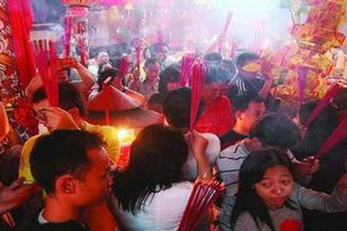 Warga berjejal sambil membawa hio saat bersembahyang di Kelenteng Boen Tek Bio, Pasar Lama, Tangerang, Banten, Senin (23/1/2012) dini hari. Perayaan menyambut Imlek 2563 di kelenteng tersebut berlangsung semarak. 