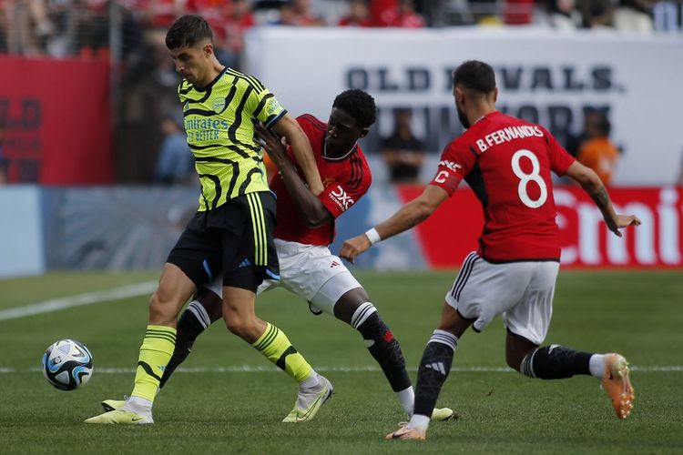 Kobbie Mainoo dan Bruno Fernandes berusaha merebut bola dari Kai Havertz dalam laga pramusim Arsenal vs Man United di Stadion MetLife, New Jersey, Minggu (23/7/2023) pagi WIB. 