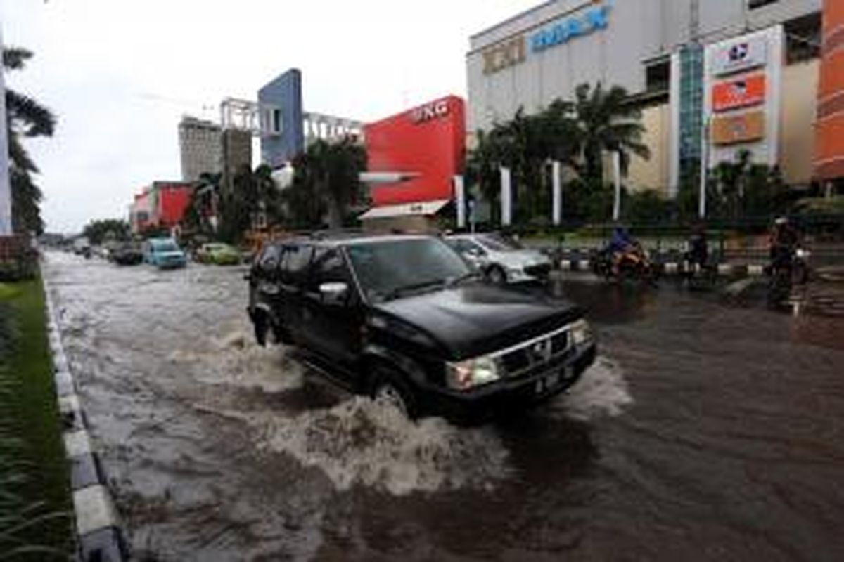 Pengendara melintasi genangan di Jalan boulevard, Kelapa Gading Jakarta Utara, Jumat (17/1/2014). Hujan lebat mengguyur Jakarta sejak pagi, membuat sejumlah jalanan Ibukota tergenang. Warta Kota/Angga Bhagya Nugraha 