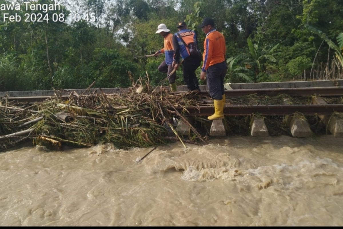 Petugas PT KAI melakukan perawatan pelintasan KA yang terendam banjir di wilayah Kabupaten Grobogan, Jawa Tengah, Selasa (6/2/2024).