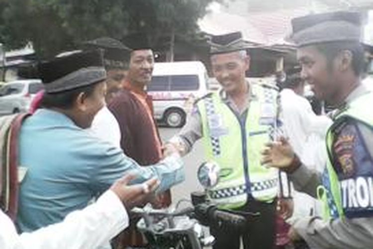 Aiptu Eko Cahyono, polisi lalu lintas dari Polres Parepare, Sulawesi Selatan, diserbu oleh ribuan warga, Kota Parepare, yang ikut shalat Idul Fitri di Lapangan Andi Makkasau Kota Parepare, Sulawesi Selatan, Jumat (17/7/2015). 