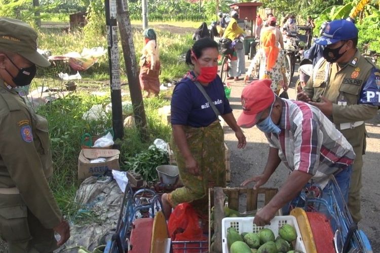 Petugas Satpol PP Kabupaten Tegal membubarkan pedagang yang masih nekat berjualan meski pasar ditutup sementara setelah ada puluhan pedagang Pasar Kupu positif Covid-19, Rabu (18/11/2020).