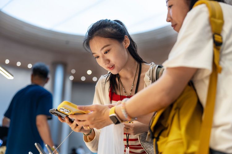 Pelanggan menjajal iPhone 16 di Apple Store Jingan Shanghai, China.