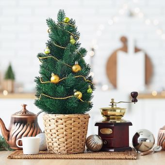 Ilustrasi pohon natal kecil di atas meja. 