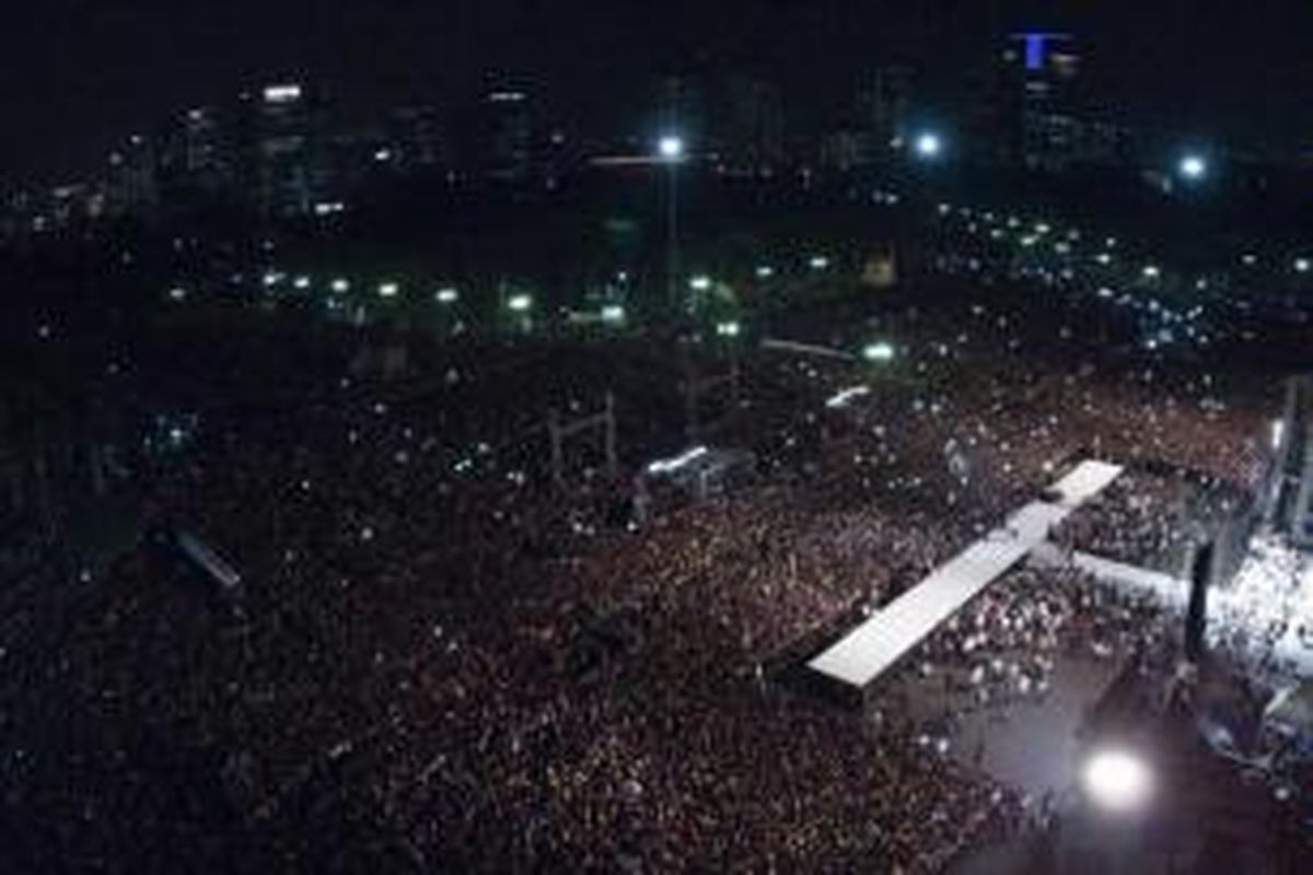 Presiden Joko Widodo (kanan) menyampaikan pidato di depan ribuan warga dalam Syukuran Rakyat Salam Tiga Jari di Lapangan Monas, Jakarta, Senin (20/10/2014). Syukuran diselenggarakan rakyat untuk menyambut presiden baru.