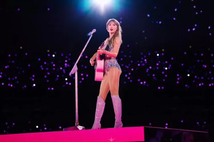 Foto Taylor Swift saat memegang gitar pink dengan outfit bling-bling di atas panggung. Foto ini diambil dalam sesi Lover di konser Eras Tour. Foto ini didaftarkan ke Kantor Paten dan Merek Dagang Amerika Serikat pada 24 April 2026.


