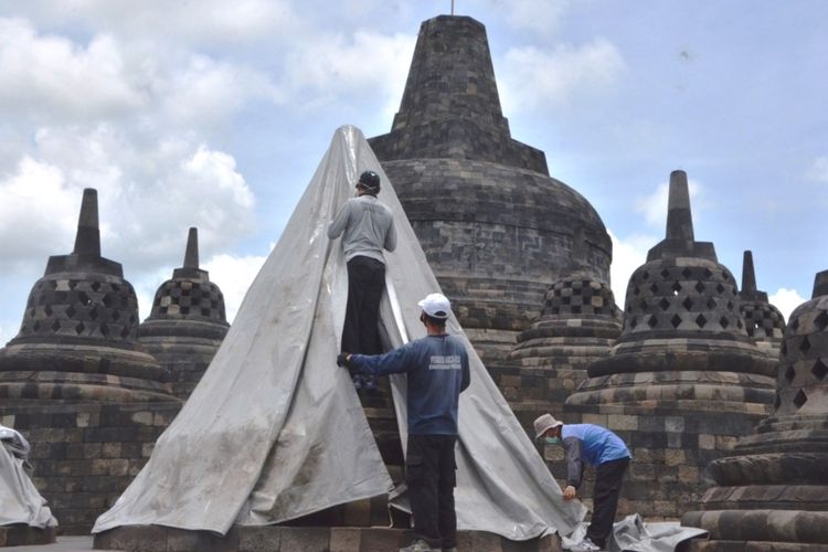 Petugas Balai Konservasi Borobudur sedang memasang terpaulin di stupa Candi Borobudur guna mengantisipasi hujan abu vulkanik Gunung Merapi, Rabu (11/11/2020).