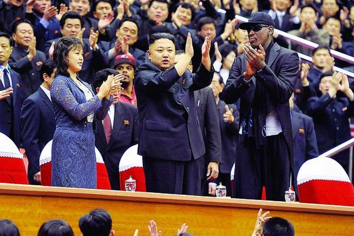 Pemimpin Korea Utara Kim Jong Un (tengah) bersama istrinya, Ri  Sol Ju (kiri), bertemu mantan bintang NBA, Dennis Rodman (kanan). Mereka menjadi penonton sebuah pertandingan bola basket di Pyongyang, Korea Utara, Jumat (1/3). Selain sebagai kunjungan diplomatik melalui basket, kunjungan Rodman ke Pyongyang juga untuk rekaman sebuah acara yang akan ditayangkan kanal HBO, April 2013. Rodman datang bersama tiga pemain klub basket Harlem Globetrotters. 