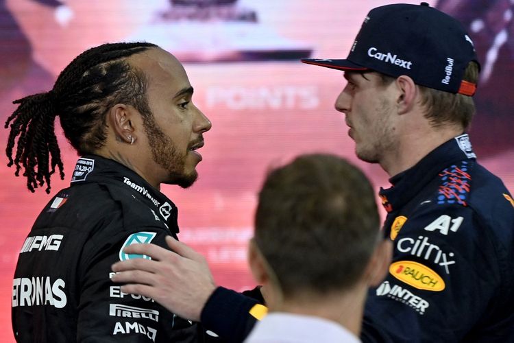 Lewis Hamilton memberi selamat atas gelar juara dunia Formula 1 (F1) yang diraih Max Verstappen pada GP Abu Dhabi 2021. (Photo by ANDREJ ISAKOVIC / AFP)
