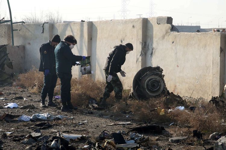 Petugas berkumpul di lokasi jatuhnya pesawat Ukraina di Parand, wilayah barat daya Teheran, Rabu (8/1/2020) pagi waktu setempat. Pesawat berjenis Boeing 737-800 itu jatuh tak lama setelah lepas landas dari Bandara Internasional Imam Khomeini, Teheran, Iran.
