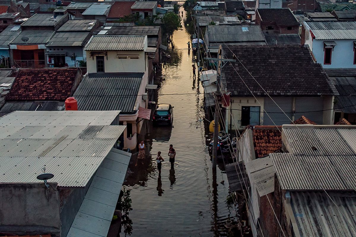 Sejumlah warga beraktifitas di tengah banjir rob yang merendam permukiman mereka di Desa Sriwulan, Sayung, Demak, Jawa Tengah, Senin (1/6/2020). Berbagai upaya dilakukan warga setempat untuk dapat beraktivitas di tengah ancaman pasang air laut yang merendam permukiman mereka ketika musim air pasang laut tinggi (rob) tiba. Warga berharap pemerintah segera menangani permasalahan rob yang kini telah mencapai jalur utama Pantura Demak.