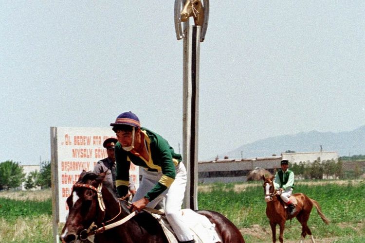 Seorang joki menyelesaikan balapan dengan kuda Akhal Teke-nya di hippodrome (arena pacuan kuda) di Ashgabat. Mungkin tidak cocok dengan kemegahan acara Royal Ascot Inggris, dengan topi dan ekornya yang top, sampanye dan perancang yang apik, tetapi satu hari balapan di republik Turkmenistan Asia Tengah yang miskin sama menyenangkannya. Foto diambil 24 Mei.