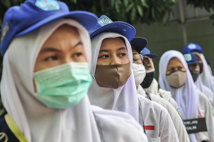 Sejumlah siswi baru mengikuti upacara di SMAN 2 Bekasi di Jawa Barat, Senin (13/7/2020). Menurut pihak sekolah sebanyak 48 siswa baru dari 384 peserta didik baru menjadi perwakilan mengikuti upacara bendera, yang merupakan rangkaian kegiatan Masa Pengenalan Lingkungan Sekolah (MPLS) selama tiga hari.