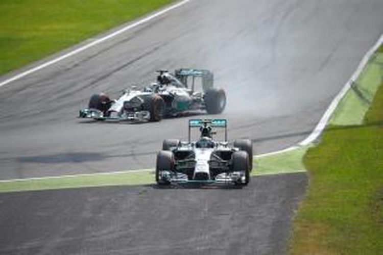 Pebalap Mercedes asal Jerman, Nico Rosberg (kanan), melakukan kesalahan saat melewati tikungan zig-zag pertama Sirkuit Monza pada GP Italia, Minggu (7/9/2014). Rekan satu timnya dari Inggris, Lewis Hamilton (kiri), melewati jalur normal dan akhirnya mengambil alih pimpinan.