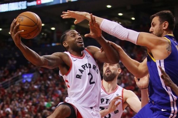 Pemain Toronto Raptors, Kawhi Leonard, mencoba memasukkan bola ke ring dengan diadang pemain Golden State Warriors pada gim kedua Final NBA di Scotiabank Arena, Toronto, Canada, Senin 3 Juni 2019.