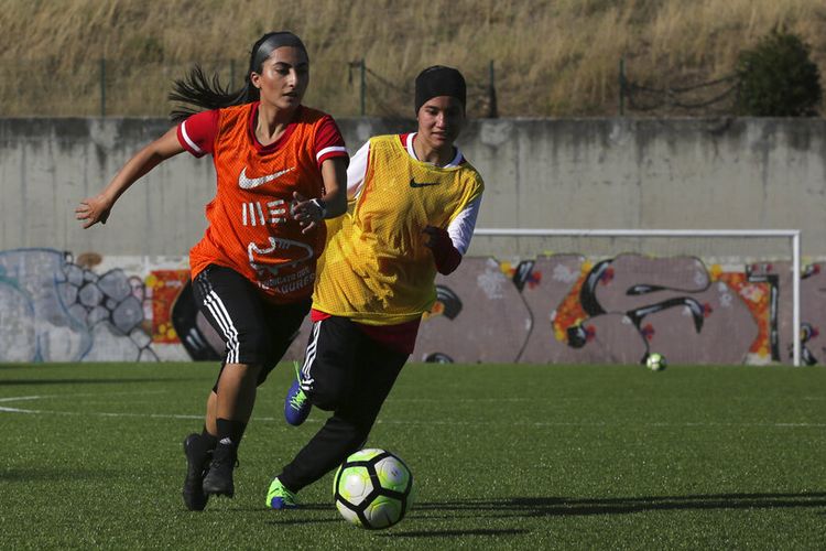 Farkhunda Muhtaj, kiri, kapten tim sepak bola wanita Afghanistan, dalam sesi latihan dengan rekan satu timnya di lapangan sepak bola di Odivelas, luar Lisbon, Kamis, 30 September 2021. 