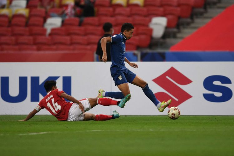 Pemain Indonesia Asnawi Mangkualam Bahar (kiri) beradu dengan pemain Thailand Bordin Phala pada pertandingan leg pertama final Piala AFF 2020 antara Indonesia vs Thailand di National Stadium, Singapura, Rabu (29/12/2021) malam WIB. Timnas Indonesia takluk 0-4 dari Thailand pada laga leg pertama final Piala AFF 2020.