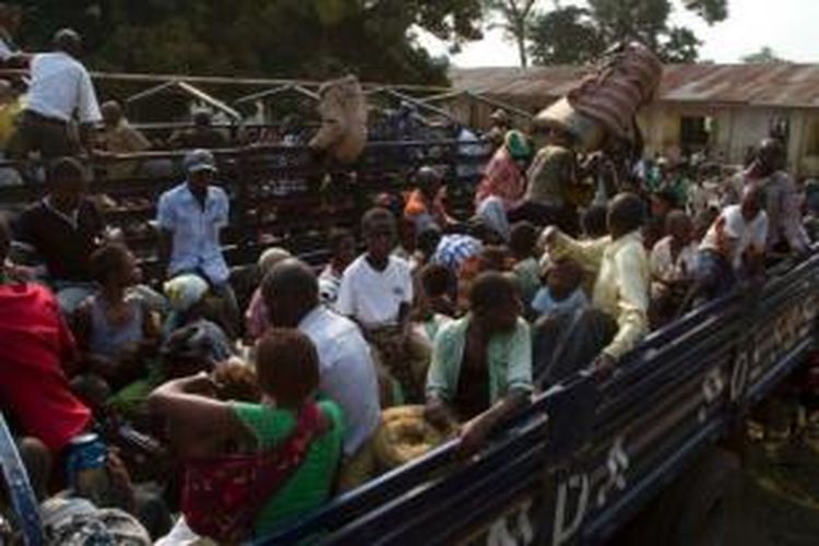 Sebuah truk polisi Uganda membawa para pengungsi dari Republik Demokratik Kongo yang tiba di kota Bubukwanga, Uganda pada 14 Juli 2013. Pertempuran yang menghebat di wilayah timur RD Kongo membuat arus pengungsi ke Uganda terus bertambah.