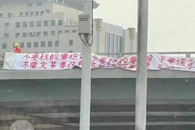 ?Si pengunjuk rasa misterius di China diyakini adalah pria yang mengenakan helm dan pakaian oranye dalam foto ini.