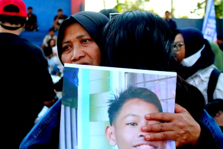 Keluarga korban meninggal saling berpelukan saat akan kirim doa memperingati satu tahun Tragedi Kanjuruhan di gate 13 Stadion Kanjuruhan Kabupaten Malang, Minggu (1/10/2023) siang.