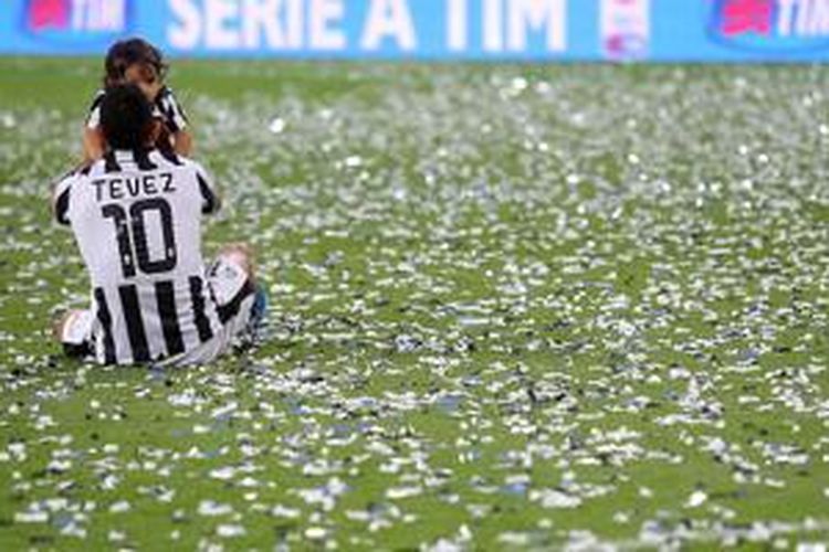 Carlos Tevez merayakan keberhasilan juara Juventus bersama anaknya, Sabtu (23/5/2015). 