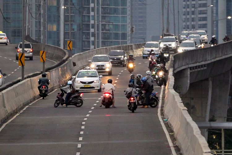 Pengendara sepeda motor nekat melawan arah saat berlangsung razia di jalan layang non tol (JLNT) Kampung Melayu-Tanah Abang, Jakarta, Selasa (25/7/2017). Pengendara motor masih nekat memasuki dan melintasi JLNT tersebut baik dari arah Tanah Abang maupun Kampung Melayu. KOMPAS IMAGES/KRISTIANTO PURNOMO