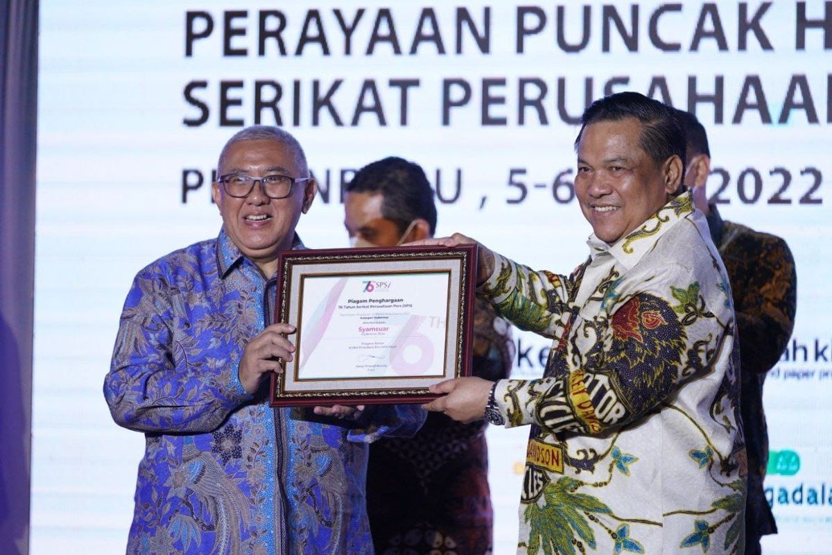 Ketua Harian SPS Pusat Januar P Ruswita menyerahkan penghargaan dan menobatkan Gubernur Riau Syamsuar sebagai Pemimpin Terpopuler di Media Arus Utama, Kategori Gubernur dalam acara Malam Selebrasi dan Penghargaan Perayaan Puncak Hari Ulang Tahun (HUT) Serikat Perusahaan Pers ke-76 di Hotel Premiere Pekanbaru, Rabu (6/7/2022).
