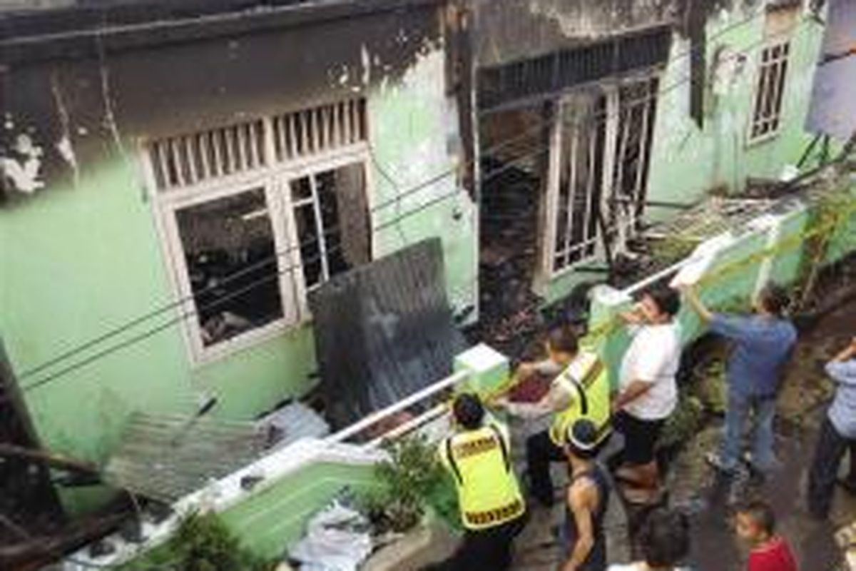 Garis polisi mulai dipasang petugas pada rumah yang terbakar di kawasan padat penduduk Pondok Kacang, Selasa (7/7/2015) sore.