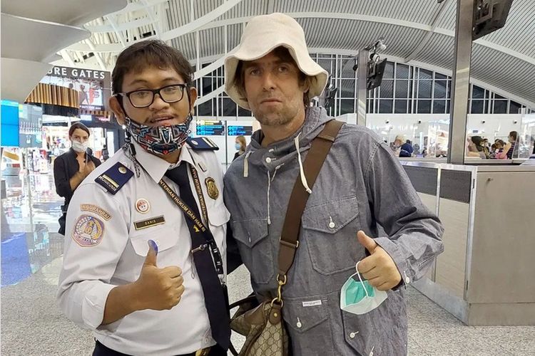 Petugas imigrasi di Bandara Ngurah Rai Bali, Rizqi Ganis Ashari berfoto dengan musisi Liam Gallagher yang berkunjung ke Bali.