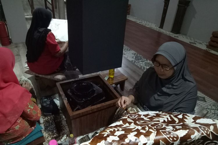 Pengrajin batik sedang memeragakan membatik tulis. Selain peragaan membatik tulis, di lantai dua Museum Trupark, Trusmi, Plered, Cirebon juga diperagakan cara membatik cap, dan mencelup batik. 