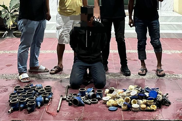FGN (jongkok) tersangka pencurian dan barang bukti meter air saat digelandang di Mapolresta Gorontalo Kota. FGN nekat mencuri karena terlilit hutang.