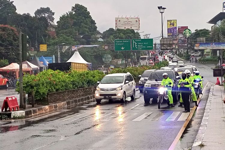 Sejumlah petugas kepolisian sedang membuka ruas jalan yang sempat diberlakukan one way atau satu arah di Simpang Gadog, Ciawi, Kabupaten Bogor, Jawa Barat, Minggu (25/12/2022) petang.