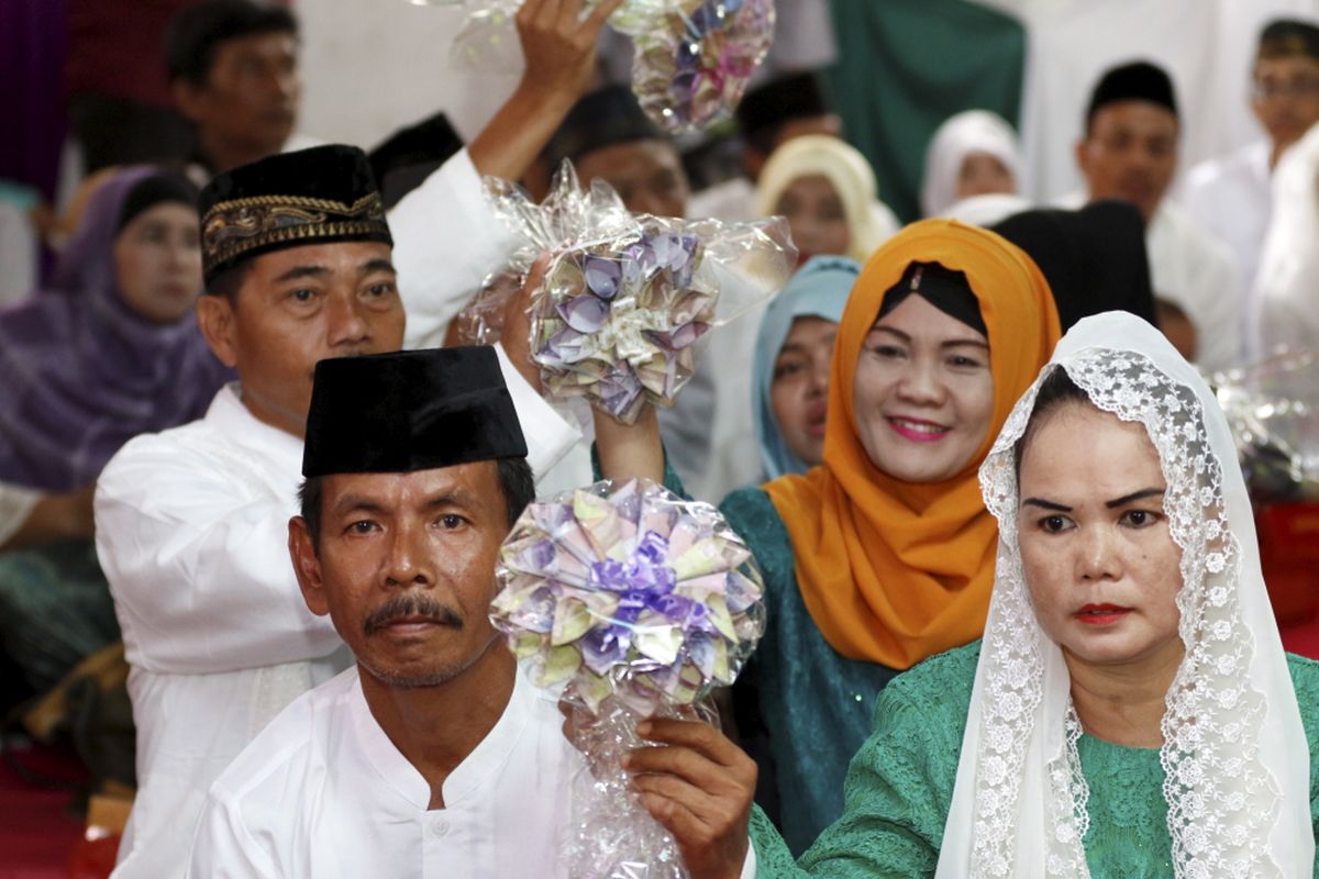 Pasangan pengantin mengikuti nikah massal yang diselenggarakan Partai Kebangkitan Bangsa di KUA Menteng, Jakarta Pusat, Jumat (25/8/2017). Sebanyak 103 pasangan pengantin mengikuti acara ini.