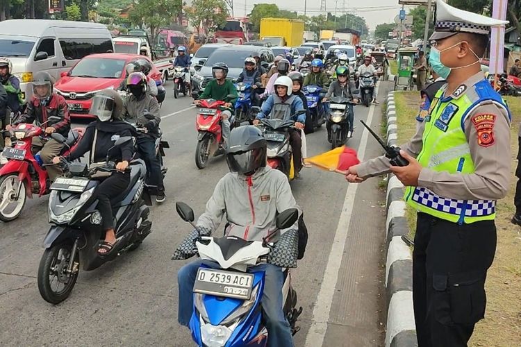 Petugas kepolisian siaga di jalur Pantura depan Terminal Harjamukti Kota Cirebon untuk mengatur arus lalu lintas pemudik yang terus mengalami peningkatan, Kamis (4/4/2024).
