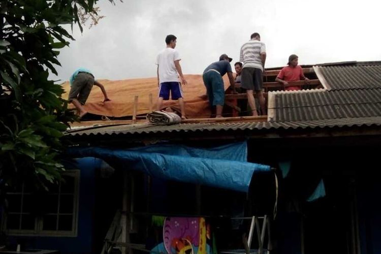 Warga tengah bahu-membahu membenahi atap rumah yang rusak akibat terjangan angin puting beliung di Kecamatan Kotabaru, Karawang, Sabtu (30/1/2021).