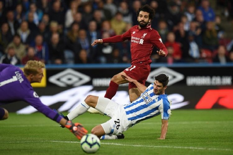 Sepakan Mohamed Salah tak bisa ditahan oleh Christopher Schindler dan kiper Jonas Lossl saat Huddersfield Town vs Liverpool beradu di Stadion John Smiths dalam lanjutan Premier League, 20 Oktober 2018. 