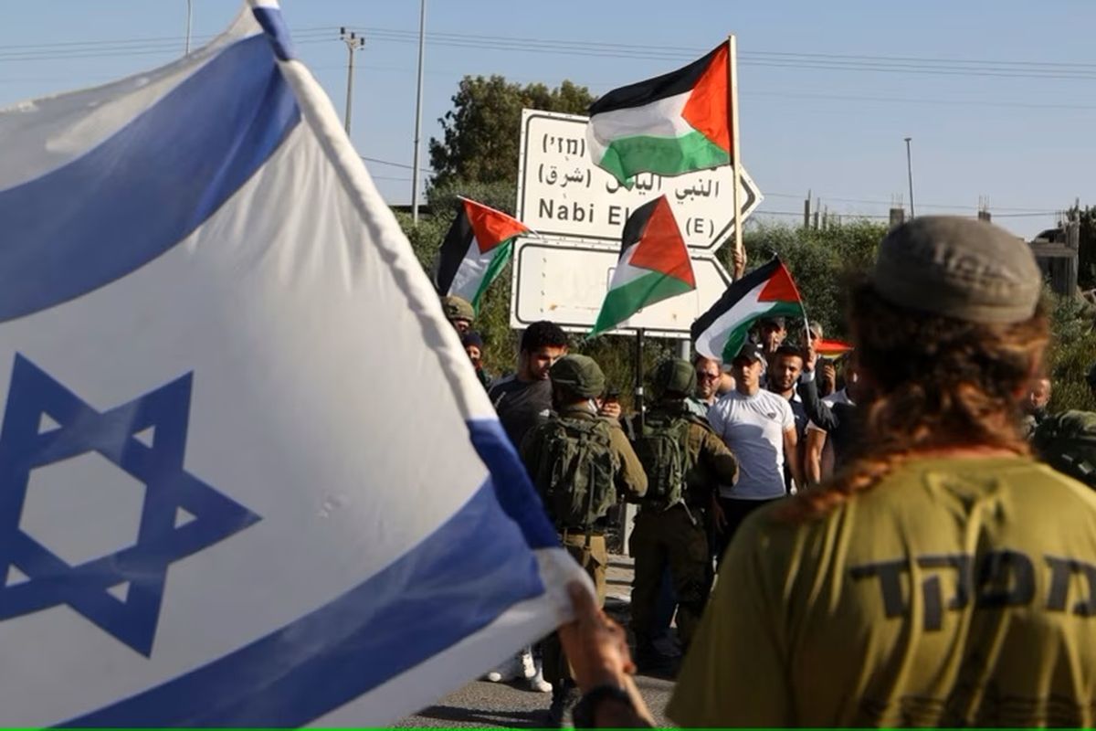 Pasukan keamanan Israel berdiri di antara Pemukim Yahudi dan warga Palestina dalam aksi protes di Qalqiliya, Tepi Barat, pada 9 Mei 2022.