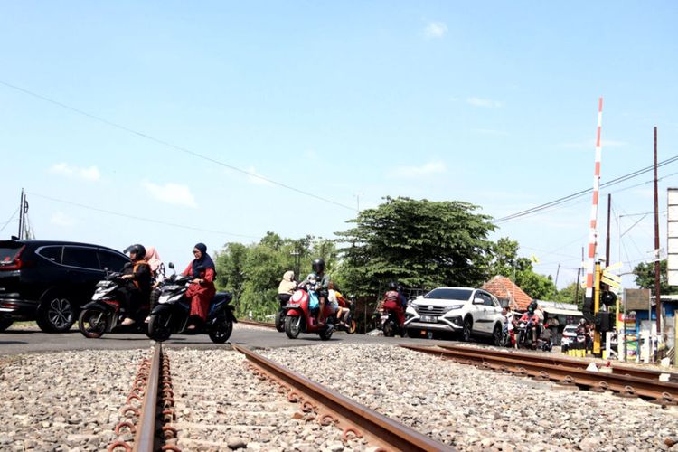 Warga pengguna jalan menyeberangi rel kereta api di perlintasan sebidang yang ada di wilayah Daop 7 Madiun, Kamis (14/12/2023)