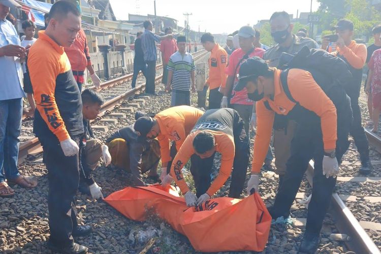 Petugas Command Center 112 Surabaya mengevakuasi korban S yang tertabrak kereta api di perlintasan rel kereta api Jalan Tambak Mayor Utara, Asemrowo, Surabaya, Minggu (8/9/2024).